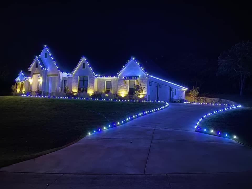 Blue and white roofline lights with lit driveway and walkway borders